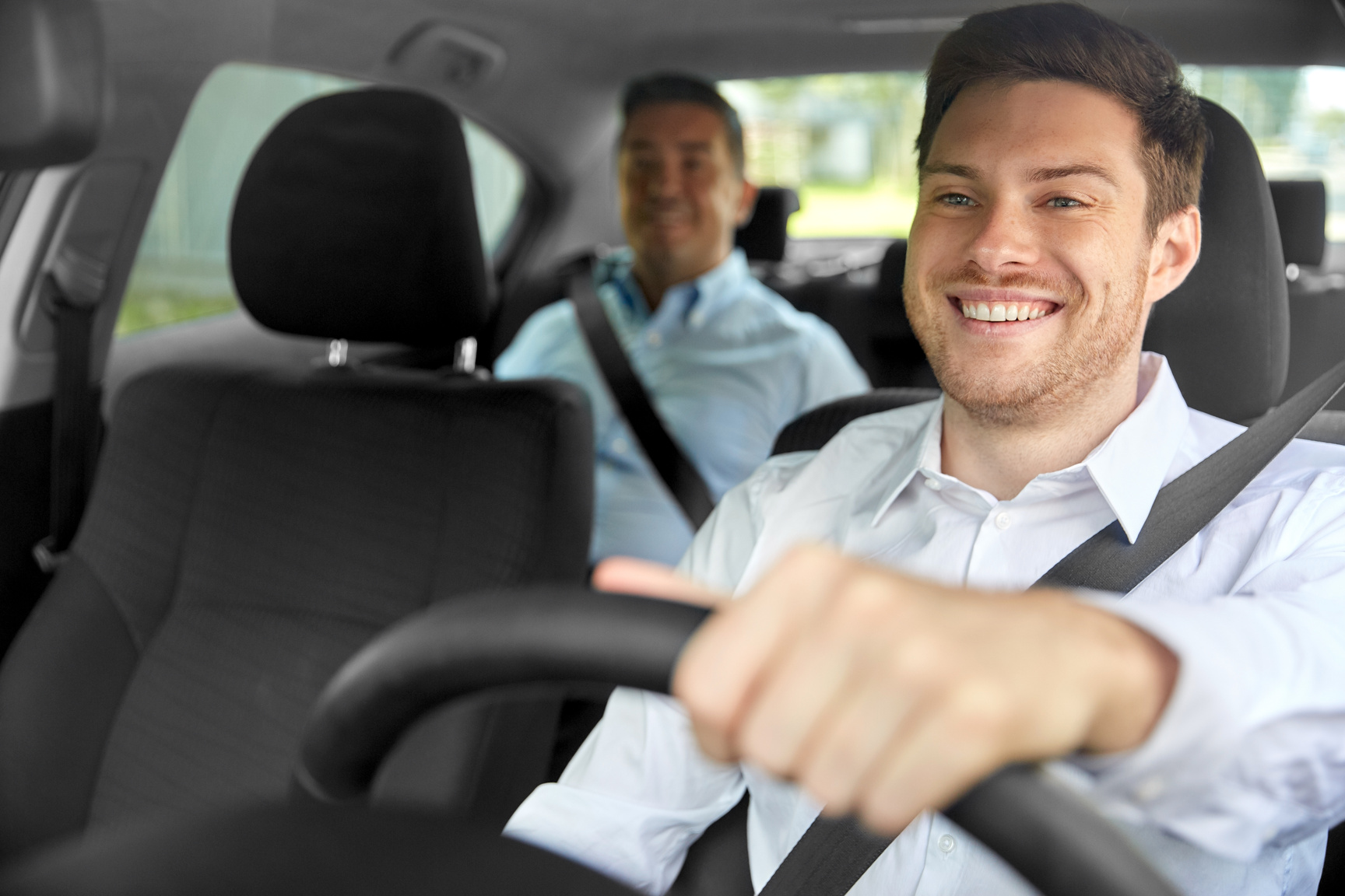 Male Taxi Driver Driving Car with Passenger